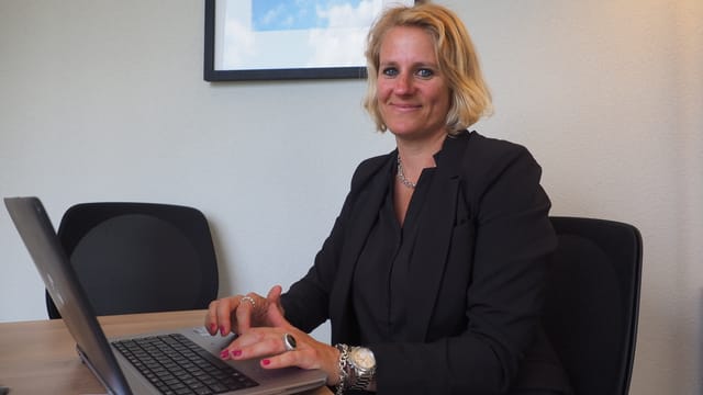 Eine Frau sitzt an einem Laptop. Eine Frau sitzt an einem Laptop.