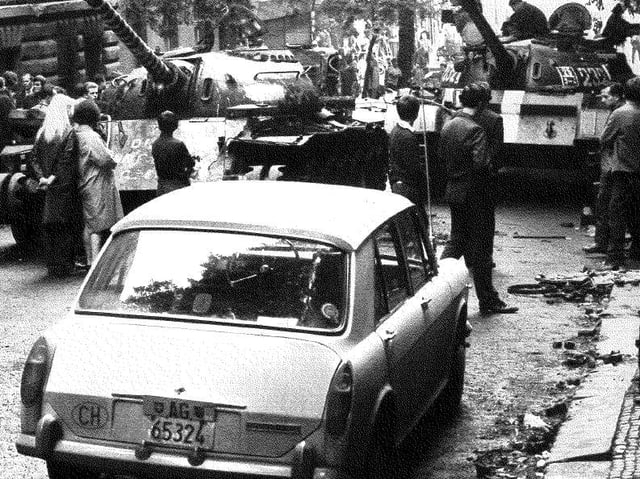 Ein Auto mit CH-Nummernschild steht vor Panzern. Ein Auto mit CH-Nummernschild steht vor Panzern.