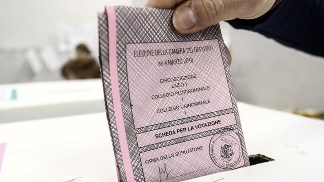 Hand wirf einen ros Wahlzettel in eine Urne. Hand wirf einen ros Wahlzettel in eine Urne.