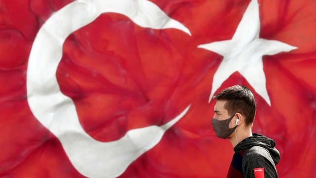 Ein Mann mit einer Maske vor einer Türkei-Flagge Ein Mann mit einer Maske vor einer Türkei-Flagge