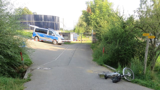 E-Bike liegt auf der Strasse. Im Hintergrund steht ein Polizeiwagen. E-Bike liegt auf der Strasse. Im Hintergrund steht ein Polizeiwagen.