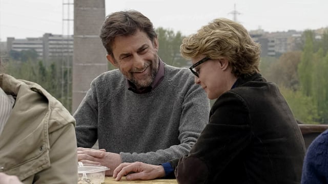 Ein Mann und eine Frau an einem Tisch sitzend, verhalten lachend im Gespräch. Ein Mann und eine Frau an einem Tisch sitzend, verhalten lachend im Gespräch.