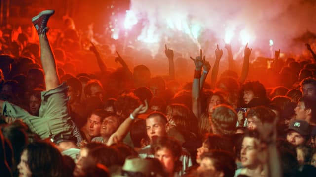 Ein Mann springt an einem Rockkonzert kopfüber in die Menge. Ein Mann springt an einem Rockkonzert kopfüber in die Menge.