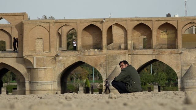 Mann sitzt in Isfahan, Iran in der Nähe einer Brücke. Mann sitzt in Isfahan, Iran in der Nähe einer Brücke.