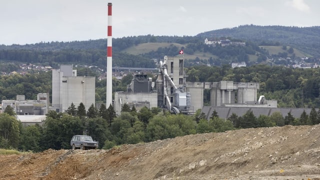 Brauner Hügel im Vordergrund, Fabrik im Hintergrund. Brauner Hügel im Vordergrund, Fabrik im Hintergrund.