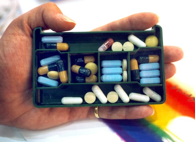 Hand mit Dose voller Medikamenten in der Hand Hand mit Dose voller Medikamenten in der Hand