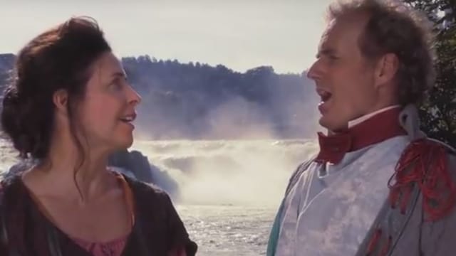 Hauptdarstellerin Masha Karell und Paul Erkamp als Gerichtsschreiber stehen singend vor dem Rheinfall Hauptdarstellerin Masha Karell und Paul Erkamp als Gerichtsschreiber stehen singend vor dem Rheinfall