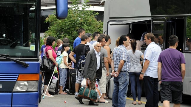 Menschen warten, um in einen Fernbus zu steigen. Menschen warten, um in einen Fernbus zu steigen.