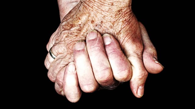 Zwei Hände, die sich halten. Die Hand eines Erwachsenen und die einer sehr alten Person / Symbolbild Zwei Hände, die sich halten. Die Hand eines Erwachsenen und die einer sehr alten Person / Symbolbild