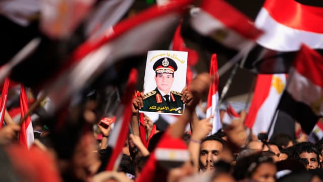 Befürworter von Abd al-Fatha al-Sisi halten sein Bild in die Höhe. Befürworter von Abd al-Fatha al-Sisi halten sein Bild in die Höhe.