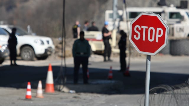 Unmik-Soldaten, Stoppschild, Stacheldraht und Verkehrshütchen an der Grenze zwischen Kosovo und Serbien. Unmik-Soldaten, Stoppschild, Stacheldraht und Verkehrshütchen an der Grenze zwischen Kosovo und Serbien.