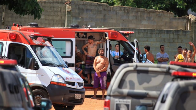 Häftlinge stehen bei einem Ambulanzfahrzeug. Häftlinge stehen bei einem Ambulanzfahrzeug.