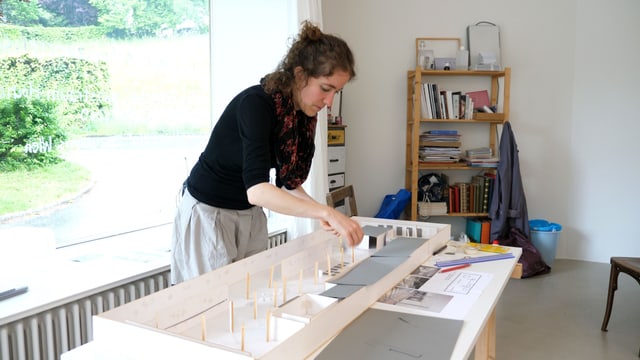 Eine Künstlerin im Atelier arbeitet an einem Modell. Eine Künstlerin im Atelier arbeitet an einem Modell.