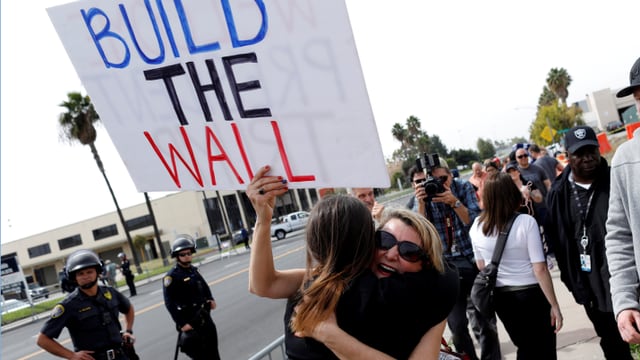 Frauen mit Plakat «Build the Wall». Frauen mit Plakat «Build the Wall».