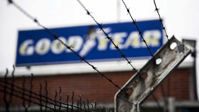 Das Logo von Goodyear am Standort Amiens in Frankreich hinter Stacheldraht. Hier sind Kaderleute zu Geiseln geworden, Arbeiter halten sie fest. (keystone) Das Logo von Goodyear am Standort Amiens in Frankreich hinter Stacheldraht. Hier sind Kaderleute zu Geiseln geworden, Arbeiter halten sie fest. (keystone)