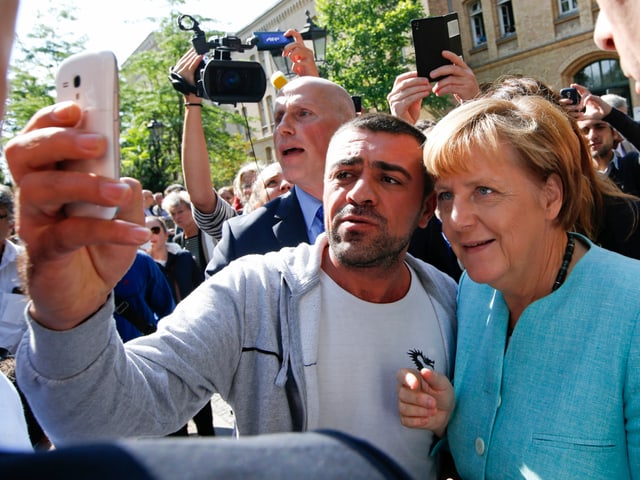 Ein Flüchtling macht ein Selfie mit Bundeskanzlerin Angela Merkel