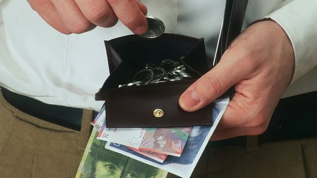 Ein Mann zieht eine Münze aus einem offenen Portemonnaie, Mehrere Banknoten hält er in der Hand. Ein Mann zieht eine Münze aus einem offenen Portemonnaie, Mehrere Banknoten hält er in der Hand.