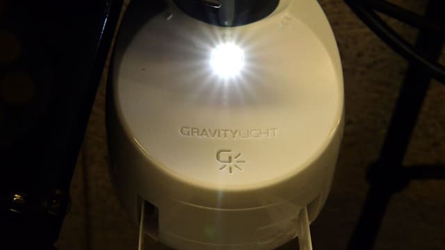 Das Gravity Light, ein Generator zum Aufhängen. An einer Kunstoffkette hängt ein schwerer Sack voller Steine, der den Generator antreibt und so Strom erzeugt. Das Gravity Light, ein Generator zum Aufhängen. An einer Kunstoffkette hängt ein schwerer Sack voller Steine, der den Generator antreibt und so Strom erzeugt.