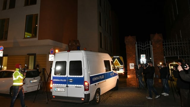 Ein Polizeiauto vor einem Gebäude, viele Medienleute Ein Polizeiauto vor einem Gebäude, viele Medienleute
