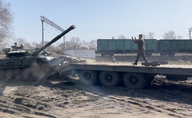 Aufladen eines Panzers auf Lastfahrzeug neben Bahngeleisen. Aufladen eines Panzers auf Lastfahrzeug neben Bahngeleisen.