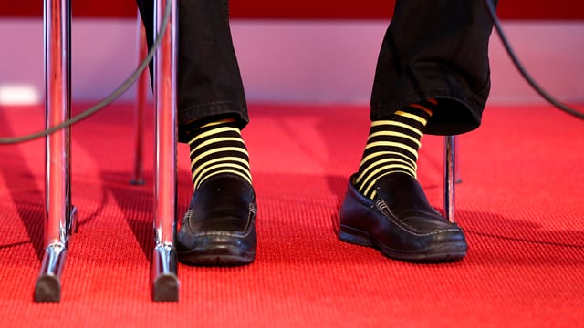 Aufnahme von Andy Rihs Füssen, die in Socken der Klubbfarbe von YB stecken. Aufnahme von Andy Rihs Füssen, die in Socken der Klubbfarbe von YB stecken.