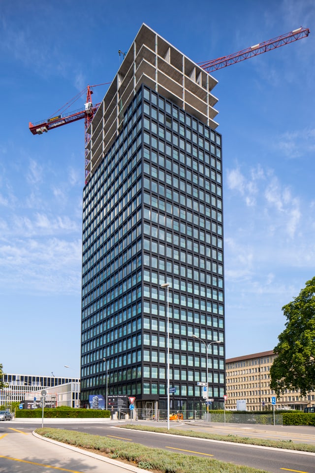 Ein unfertig gebautes Hochhaus, dahinter ein Kran Ein unfertig gebautes Hochhaus, dahinter ein Kran