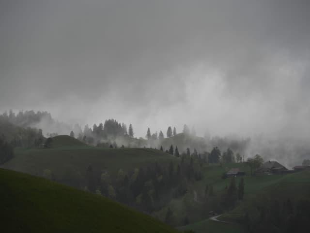 Wolkenverhangener Himmel mit grüner Hügellandschaft im Vordergrund Wolkenverhangener Himmel mit grüner Hügellandschaft im Vordergrund