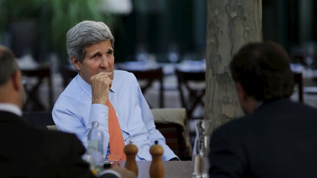 John Kerry sitzt an einem Tisch John Kerry sitzt an einem Tisch
