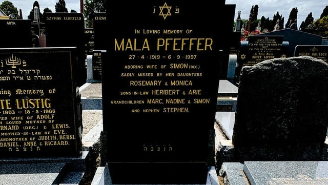 Ein schwarzer Grabstein mit der Inschrift «In Loving Memory Of Mala Pfeffer» ist im Fokus des Bilds. Ein schwarzer Grabstein mit der Inschrift «In Loving Memory Of Mala Pfeffer» ist im Fokus des Bilds.