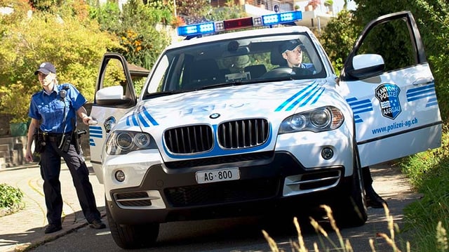 Polizisten steigen aus einem Polizeiauto aus. Polizisten steigen aus einem Polizeiauto aus.