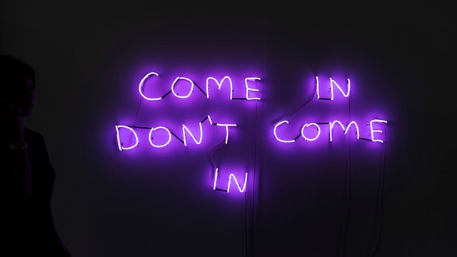 Die Worte «come in, don't come in» sind an der Art Basel mit Leuchtbuchstaben an die Wand geschrieben. Die Worte «come in, don't come in» sind an der Art Basel mit Leuchtbuchstaben an die Wand geschrieben.
