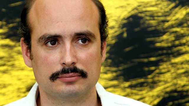 Porträt von Peter Strickland vor gelb-schwarzer Wand. Porträt von Peter Strickland vor gelb-schwarzer Wand.