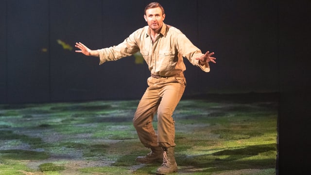 Ein Mann im beigen Outfit steht auf der Bühne. Szene aus «Peter Gynt». Ein Mann im beigen Outfit steht auf der Bühne. Szene aus «Peter Gynt».