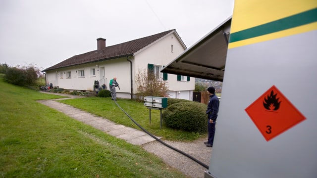 Ein Tankwagen liefert einem Einfamilienhaus-Besitzer Heizöl. Ein Tankwagen liefert einem Einfamilienhaus-Besitzer Heizöl.