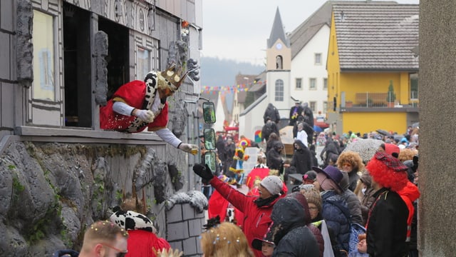 König gibt ein Glas Bier an die Zuschauer, aus dem Fenster seiner "Burg" König gibt ein Glas Bier an die Zuschauer, aus dem Fenster seiner "Burg"