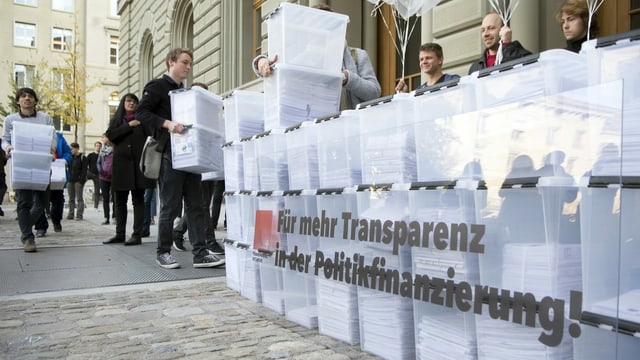 Personen laufen mit den Boxen, die Unterschriften enthalten, in Richtung Bundeshaus-West wahrend der Einreichung der Transparenz-Initiative. Personen laufen mit den Boxen, die Unterschriften enthalten, in Richtung Bundeshaus-West wahrend der Einreichung der Transparenz-Initiative.
