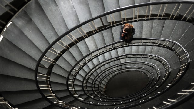 Frau läuft auf einer Wendeltreppe Frau läuft auf einer Wendeltreppe