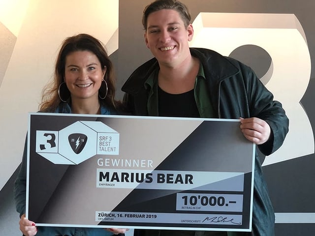 Judith Wernli und Marius Bear präsentieren den Sieger-Scheck. Judith Wernli und Marius Bear präsentieren den Sieger-Scheck.