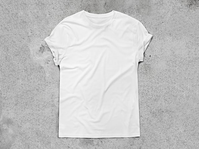 Ein weisses Shirt liegt auf einer grauen Beton-Fläche. Ein weisses Shirt liegt auf einer grauen Beton-Fläche.