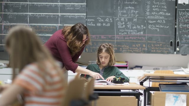Lehrerin hilft Schülerin Lehrerin hilft Schülerin