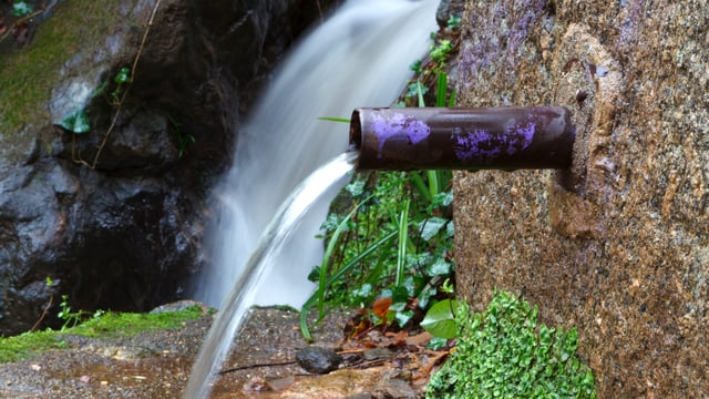 Quellwasser fliesst aus einer Brunnenröhre Quellwasser fliesst aus einer Brunnenröhre