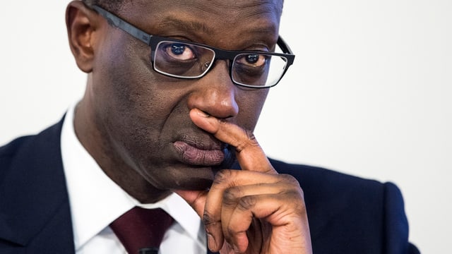 Thiam Tidjane im Porträt mit nachdenklichem Blick und auf Hand gestütztem Kopf. Thiam Tidjane im Porträt mit nachdenklichem Blick und auf Hand gestütztem Kopf.