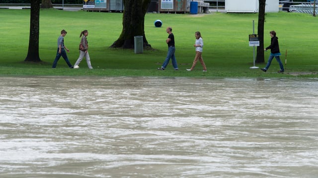 Platschvolles Aare-Flussbecken, am Ufer spatzieren Leute. Platschvolles Aare-Flussbecken, am Ufer spatzieren Leute.