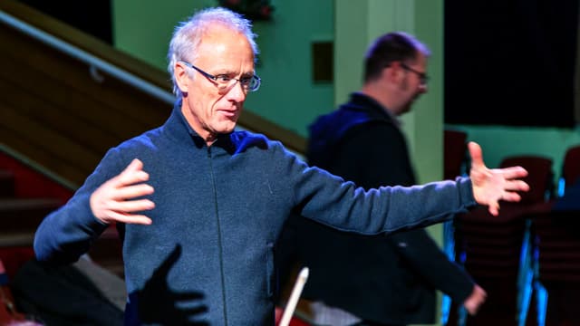 Ein Mann dirigiert ein Orchester Ein Mann dirigiert ein Orchester