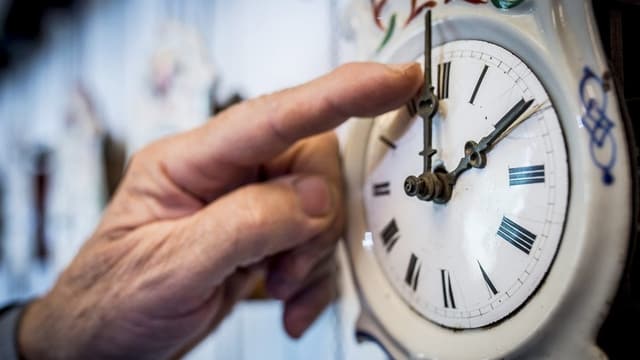 Jemand stellt die Uhr um. Jemand stellt die Uhr um.