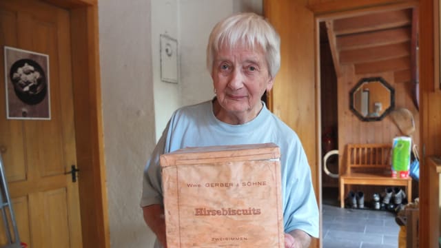 Frau hält alte Biscuitschachtel in den Händen. Frau hält alte Biscuitschachtel in den Händen.