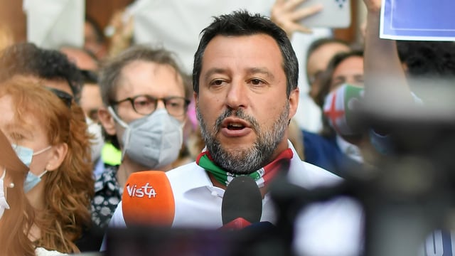 Salvini spricht in Mikrfone und Kameras inmitten einer Menschenmenge, die Maske hat er unter dem Kinn. Salvini spricht in Mikrfone und Kameras inmitten einer Menschenmenge, die Maske hat er unter dem Kinn.
