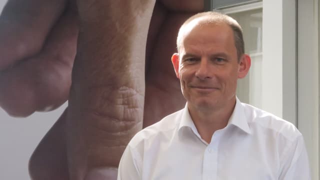 Finanzchef Bruno Edelmann steht vor einem Tornos-Plakat Finanzchef Bruno Edelmann steht vor einem Tornos-Plakat