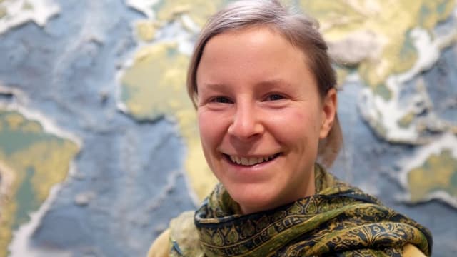 Eine Frau steht vor einer Weltkarte Eine Frau steht vor einer Weltkarte