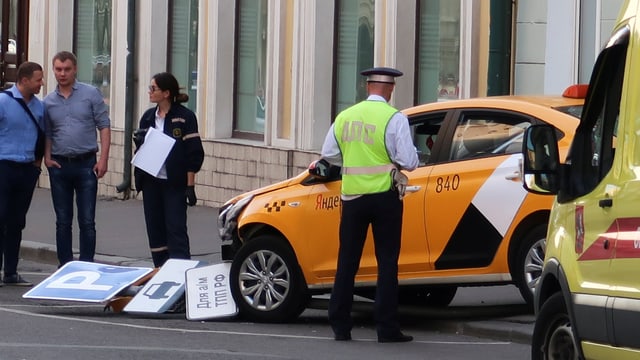 Ein Polizist steht beim Taxi Ein Polizist steht beim Taxi